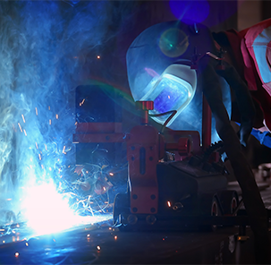 Welder with safety helmet performing welding.