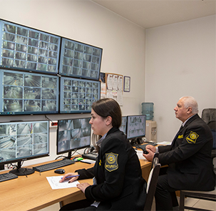 Geoohrana employees reviewing security camera footage in a CCTV room.