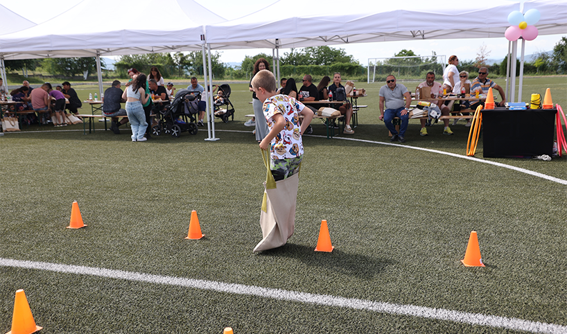 Дете играе скачане с чувал на детския празник