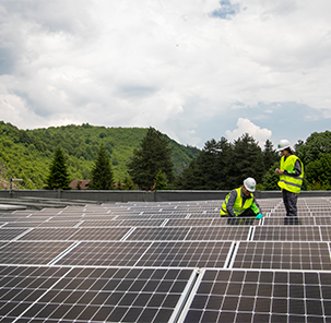 Energeo employees in protective clothing working on solar panels.