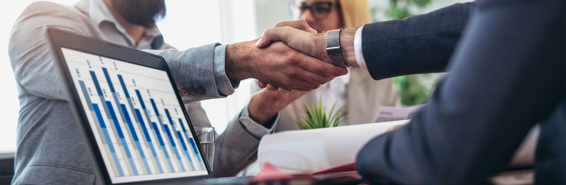 Shaking hands with business partners during a business meeting.