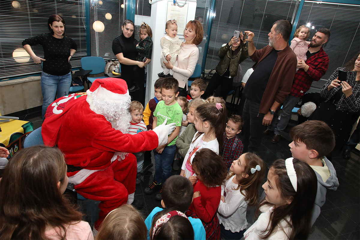 Children of employees from Geotechmin Ltd. together with Santa Claus at the Christmas Miracles event.