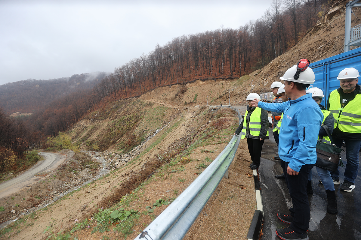 Посетители с предпазни каски и светлоотразителни жилетки на посещение на станцията на площадка с гледка