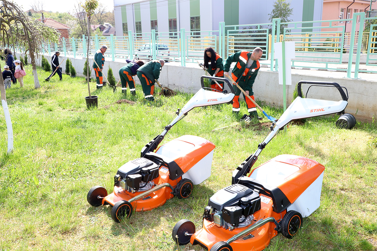 Две оранжеви косачки на марката STIHL и служители от Елаците мед засаждащи растения.